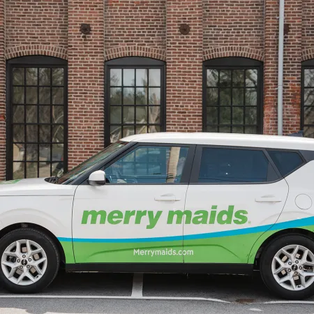 Merry Maids of Lancaster County branded service vehicle parked outside a Lancaster brick building, ready for a home cleaning visit.